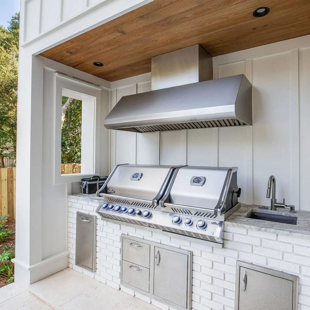 Outdoor kitchen exhaust hood illustrating ventilation considerations for a grill under a covered lanai