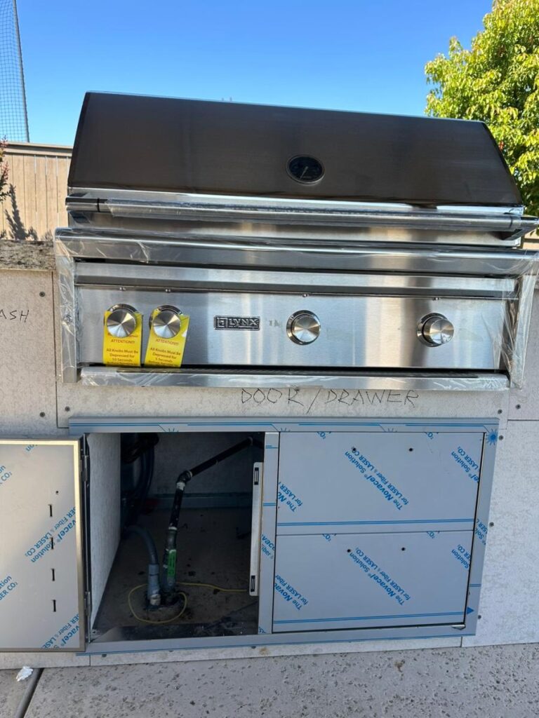 Outdoor kitchen cabinetry with access panels for utility connections and appliance servicing